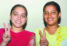 Savdeep Kaur and Sonia Kundra in jubilant mood after securing first position in B.Com (professional)-I examination of Guru Nanak Dev University in Jalandhar.